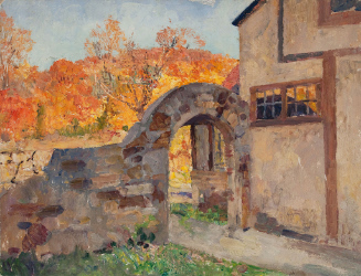 House and arched stone wall with autumn foliage on mountain in background